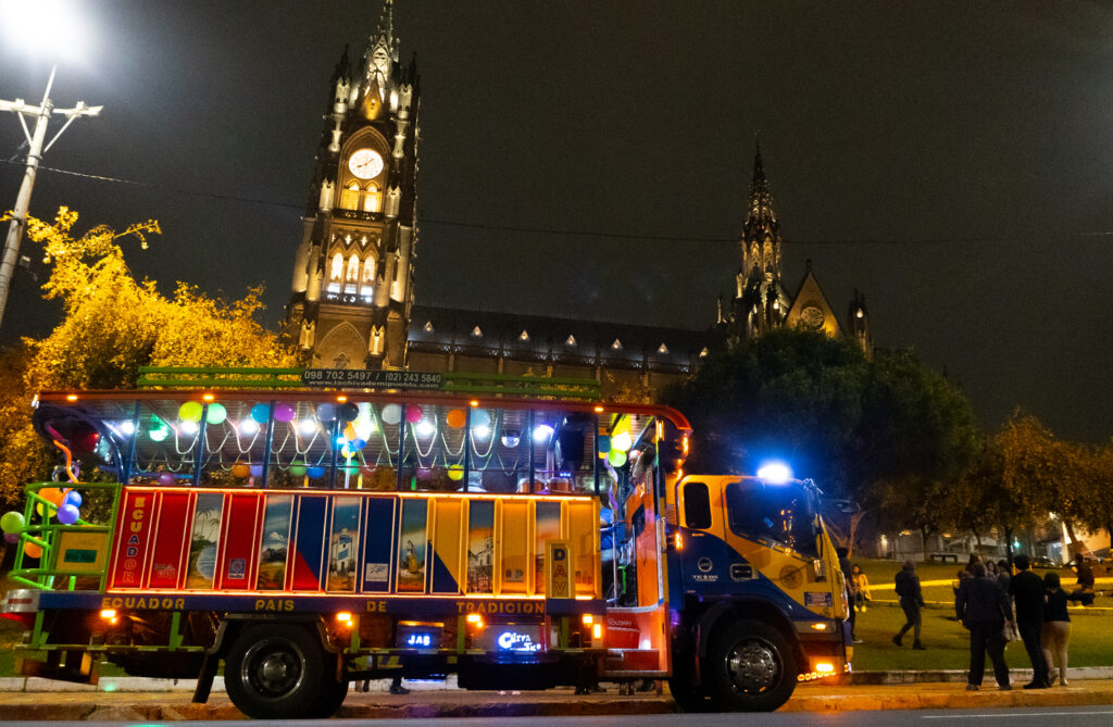 Chiva en noche con luces y la ciudad de fondo