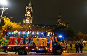 Chiva en noche con luces y la ciudad de fondo