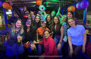 Grupo de turistas y amigos disfrutando un tour nocturno en La Chiva de Mi Pueblo con luces y ambientación festiva en la Sierra ecuatoriana