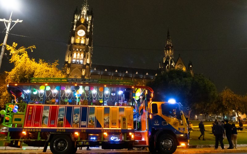 Chiva en noche con luces y la ciudad de fondo