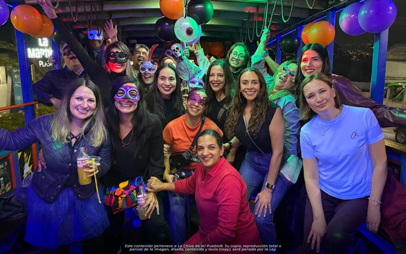 Grupo de turistas y amigos disfrutando un tour nocturno en La Chiva de Mi Pueblo con luces y ambientación festiva en la Sierra ecuatoriana